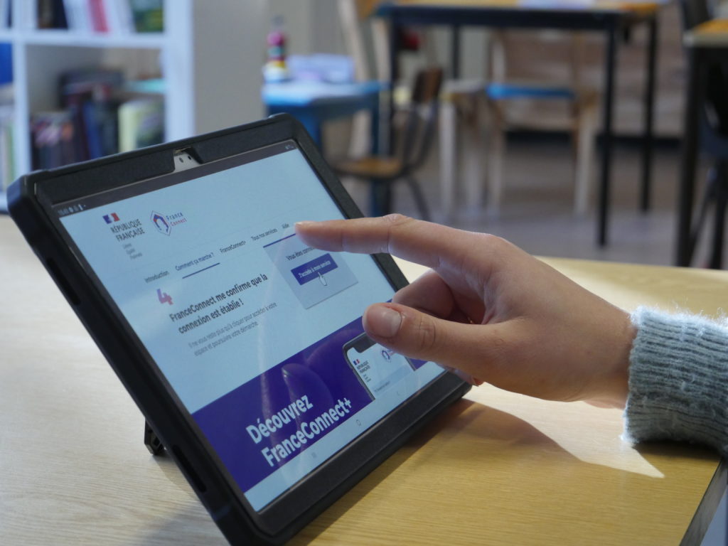 Photo d'une tablette tactile et d'une personne se connectant à France connect.